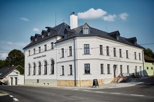 duży biały budynek z czarnym dachem w obiekcie Hotel a Hostinec Slunce w mieście Osečná