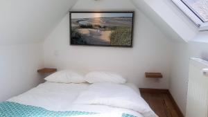 a bedroom with a bed with a picture on the wall at Villa Kady - Chalet de charme du 19ième siécle in Le Touquet-Paris-Plage