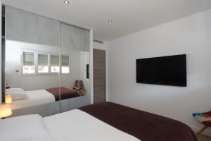 une chambre avec deux lits et une télévision à écran plat dans l'établissement Excellent Appt 2 pièces Super Croisette, à Cannes