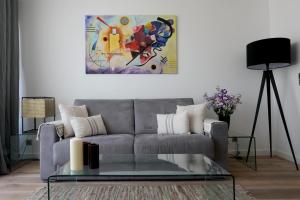 un salon avec un canapé gris et un tableau dans l'établissement Excellent Appt 2 pièces Super Croisette, à Cannes