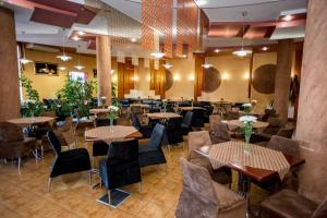 ein Restaurant mit Tischen und Stühlen in einem Raum in der Unterkunft Dalos in Sarny
