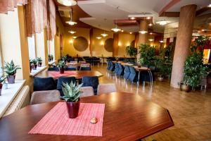 un restaurante con mesas, sillas y plantas en Dalos, en Sarny