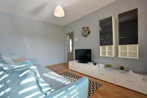 a living room with a bed and a flat screen tv at Apartament Dzień dobry in Wałbrzych