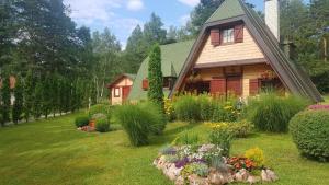 ein Haus mit einem Garten mit Blumen im Hof in der Unterkunft Višnjin Dom in Divčibare