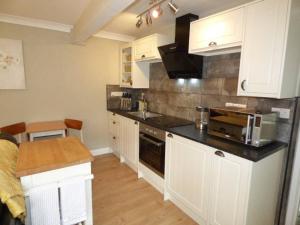 een keuken met witte kasten en een aanrecht bij No6 @ Globe Lane,Alston in Alston