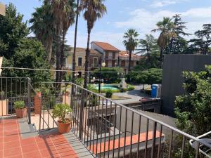 a balcony with palm trees and a pool at House S&D in Giarre