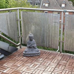a statue of a meditating woman sitting on a patio at Ferienwohnung Leo Duisburg - Nähe Bahnhof in Duisburg