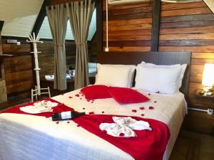 Un dormitorio con una cama grande con sábanas rojas y flores. en Mirágua Refugios Pousada en Brotas