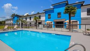 a swimming pool in front of a blue building at Best Western Shallotte / Ocean Isle Beach Hotel in Shallotte