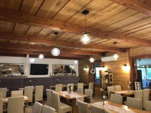 a dining room with wooden ceilings and tables and chairs at Daglezjowy Dwór in Osiek