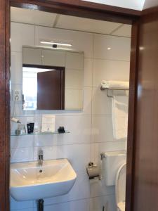 a bathroom with a sink and a mirror and a toilet at Hotel Zee en Duin in Katwijk +87 photos