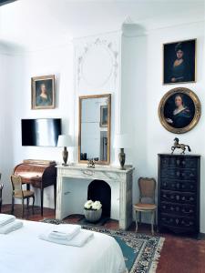 a bedroom with a fireplace and a mirror at Château de Saint-Girons B&B in Aix-en-Provence