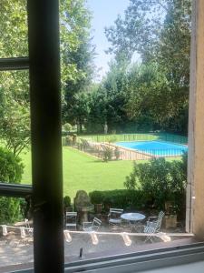 ein Fenster mit Blick auf einen Garten mit einem Pool in der Unterkunft Château de Saint-Girons B&B in Aix-en-Provence