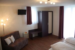 a living room with a couch and a bed and a television at Hotel Engel in Emmetten