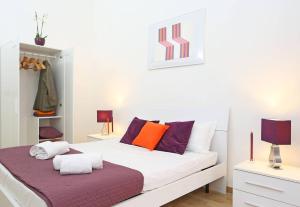 a white bed with colorful pillows in a room at Fantasie in Trastevere in Rome
