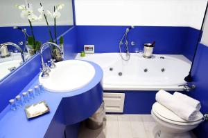 a blue bathroom with a tub and a sink and a toilet at Fantasie in Trastevere in Rome