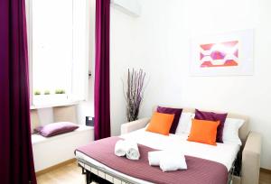 a bedroom with a bed with orange and purple pillows at Fantasie in Trastevere in Rome