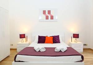 a bedroom with a large white bed with two lamps at Fantasie in Trastevere in Rome