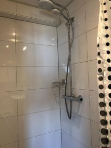 La salle de bains est pourvue d'une douche avec un pommeau de douche. dans l'établissement Hotel Zee en Duin, à Katwijk