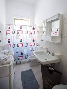 ein Badezimmer mit einem Waschbecken, einem WC und einem Spiegel in der Unterkunft Vento di Scirocco in Pozzallo