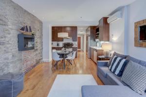 uma sala de estar com um sofá azul e uma cozinha em Les Immeubles Charlevoix - Le 1173 em Quebeque