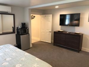 a bedroom with a bed and a television on the wall at The Surf Beach Motel in Amelia Island