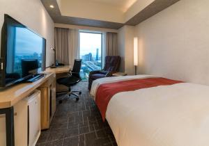 a hotel room with a bed, desk and television at Daiwa Roynet Hotel Tokyo Ariake in Tokyo