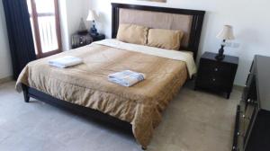a bedroom with a large bed with two towels on it at Apartment in Jebel Sifah in As Sīfah