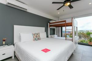 ein Schlafzimmer mit einem weißen Bett und einem Fenster in der Unterkunft Studio 30 Condhotel by Nah Hotels in Playa del Carmen