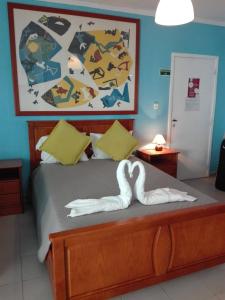 ポルティマンにあるAncora T0 Apartamento Praia da Rochaのベッドルーム1室(タオルで作られた白鳥2羽のベッド1台付)