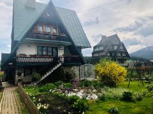 a large house with a garden in front of it at Willa Szafran - pokoje in Zakopane