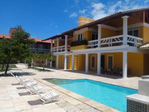 een villa met een zwembad en ligstoelen bij Hotel Porto Belo in Aquiraz