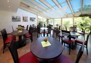 um restaurante com mesas, cadeiras e janelas em Hotel Zum Löwen - Al Leone em Meltina