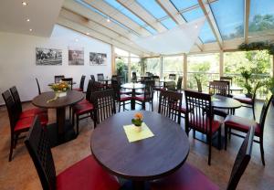 un restaurante con mesas, sillas y ventanas en Hotel Zum Löwen - Al Leone, en Meltina