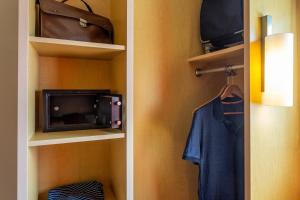 a closet with a tv and a bag on a shelf at Ibis Cancun Centro in Cancún