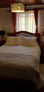 1 cama grande en un dormitorio con ventana en Hostal Casa Amarilla San Vicente de Tagua Tagua en San Vicente de Taguatagua