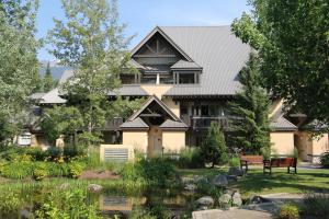 ein großes Haus mit einem Teich davor in der Unterkunft Lagoons Condos by Whistler Retreats in Whistler