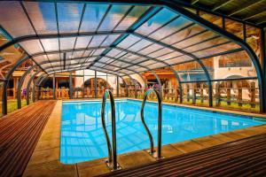 uma piscina interior com tecto de vidro em Hôtel & Spa La Ferme de l'Izoard em Arvieux