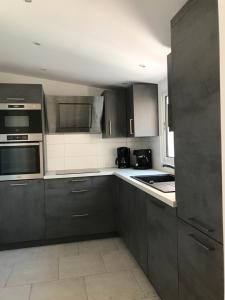 a kitchen with dark brown cabinets and appliances at Ma Ré Basse in La Flotte