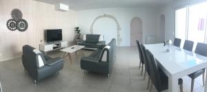 a living room with a table and chairs and a television at Ma Ré Basse in La Flotte