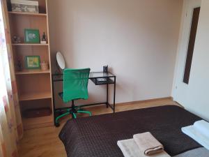 a bedroom with a green chair and a desk at Na Złotych Łanach - apartament z parkingiem in Bielsko-Biała