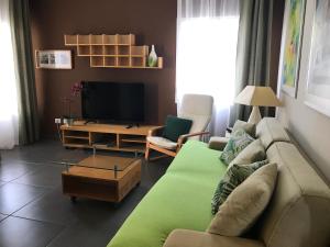 ein Wohnzimmer mit einem Sofa und einem TV in der Unterkunft Apartamento Playa Blanca Holiday in Puerto del Rosario