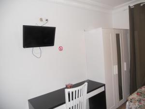 a room with a desk and a tv on the wall at Hotel Pacific in Paris