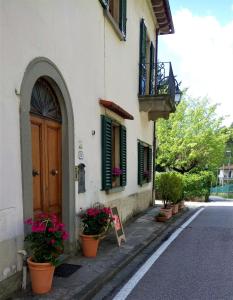 um edifício com vasos de plantas ao lado de uma rua em CASA BARTOLACCI COZY APARTMENT (NEAR FLORENCE CITY CENTER) em Bivigliano