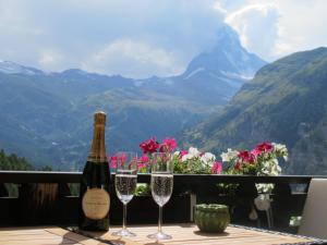 Una botella de vino y dos copas en una mesa. en Matterhorn Ried Suite, en Zermatt