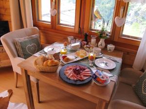 a wooden table with breakfast foods on it at Matterhorn Ried Suite in Zermatt