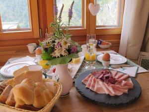 una mesa con pan y huevos y un plato de comida en Matterhorn Ried Suite, en Zermatt