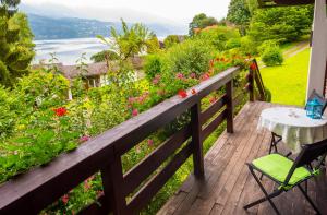 una terrazza in legno con tavolo, sedie e fiori di Waldstrand Berger a Seeboden
