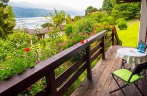 a wooden deck with a table and chairs and flowers at Waldstrand Berger in Seeboden