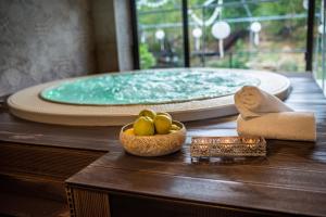 a table with a bowl of fruit and a bath tub at Hotel Kostelski Buk in Bihać